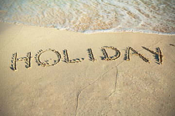 Fototapeta premium Holiday sign on the beach of Caribbean Sea in Mexico