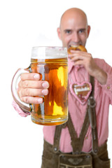 Mann in Lederhose mit Bier und Brezel