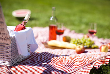 Wine and picnic basket on the grass 