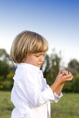 Crying young boy with finger injury outdoors