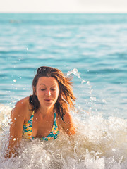 young woman playing with sea water