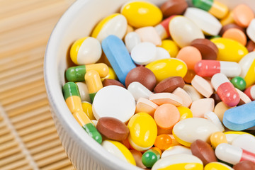 White cup filled with medicine pills and capsules