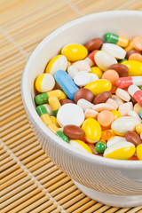 White cup filled with medicine pills and capsules