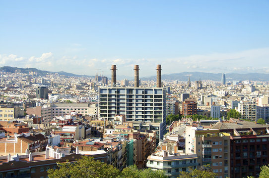 Blick auf ein Bürogebäude und Schornsteine einer alten Kraftwerksanlage im Distrikt El Poble-sec in Barcelona