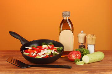 frying pan with vegetables on red background