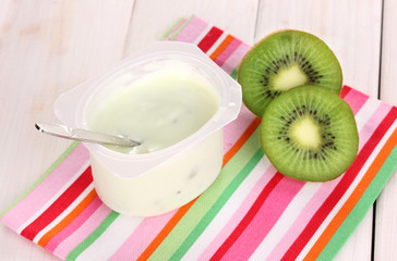 yogurt with kiwi on napkin on wooden background