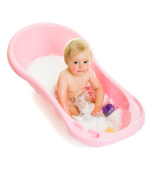Cute infant girl in bath isolated on white