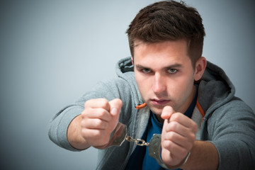 Arrested teenager with handcuffs on his hands