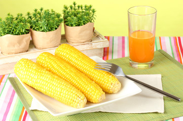 boiled corn and juice on a green background