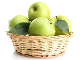 Ripe green apples with leaves in basket isolated on white