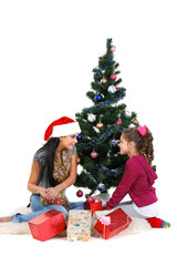 Mother and daughter near a christmas tree with gifts