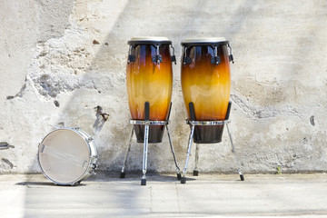 two congas in front of a vintage wall