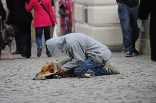Bettler mit Hund in der Stadt