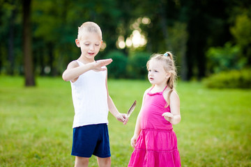 Little boy and girl  with ladybird in park