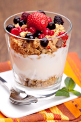 yogurt with muesli and berries in small glass