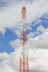 Telecommunication mast with cloudy sky.