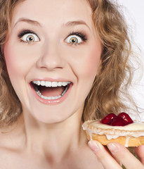 Woman eating a cake. In studio