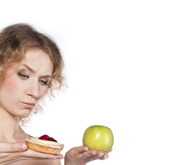 Young cheerful woman, choosing between apple and cake