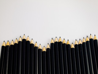 Wave of black pencils on white background