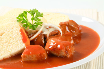 Pork meat in tomato sauce with dumplings