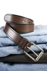 Stack of various shades of blue jeans with brown belts