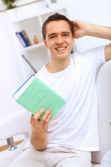 Young man at home with a book