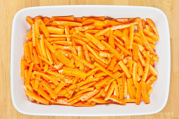 Peeled and sliced fresh organic carrots with olive oil