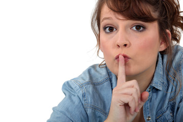 Fototapeta premium Young woman requesting for silence, studio shot