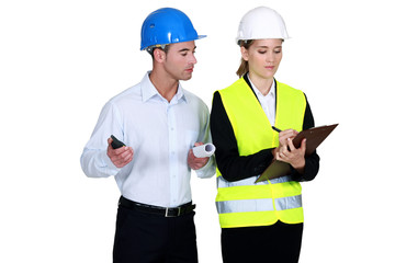 Engineer peering over a surveyor's shoulder