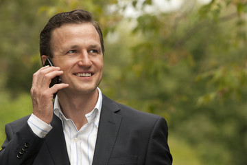 Businessman smiling while having conversation on mobile phone