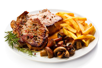 Grilled steaks, French fries and vegetables