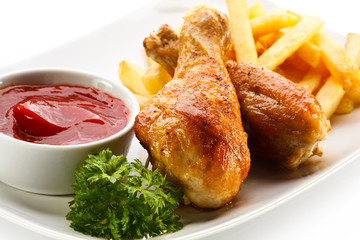 Grilled chicken drumsticks with chips and vegetables
