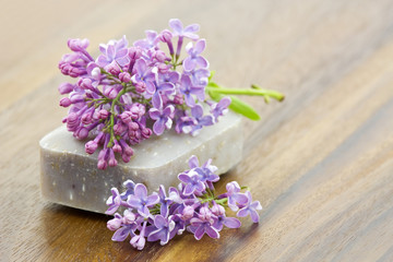 bar of natural soap and lilac flowers