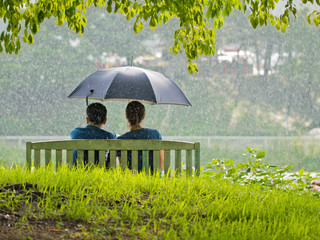 A couple on the bench under umbrella