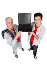 Two men showing a laptop computer