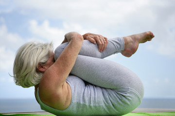 Woman holding a yoga position - obrazy, fototapety, plakaty