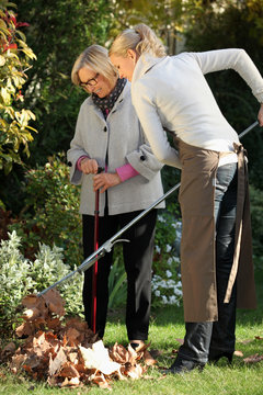 Young Woman Helping Elderly Woman To Do Gardening