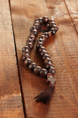 the Wooden rosary beads on wooden background close-up