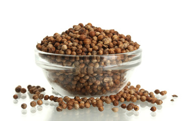 Heap coriander seeds in glass bowl isolated on white