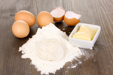 Eggs, flour and butter close-up on wooden table
