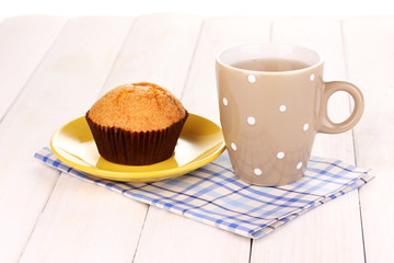 Fresh muffin with tea on wooden background