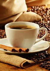 Composition with white cup of coffee and beans