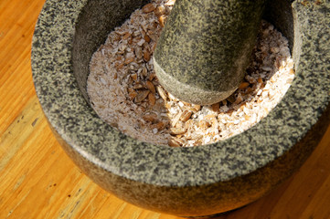Corn being grinded with mortar and pestle
