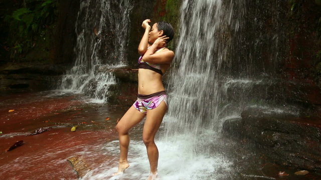 Sexy dancer on waterfall in borneo rainforest