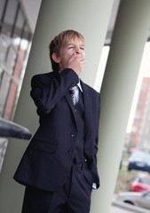 Teenager in business suit yawning.