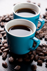 Vertical shot of two espresso cups and roasted coffee beans