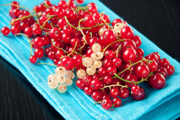 Horizontal shot of red currant on a turquoise serviette