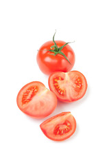 Fototapeta premium Vertical shot of a whole ripe tomato and its slices on white