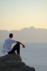 Fototapeta premium Man sits on a stone