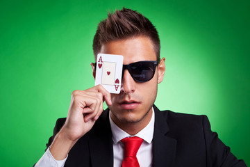business man covers one eye with an ace of hearts